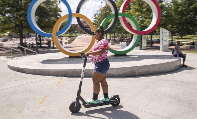 A woman rides a shareable e-scooter in Centennial Olympic Park in Atlanta.