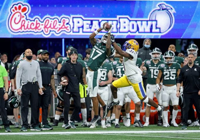 Michigan State Spartans wide receiver Tre Mosley (17) catches a pass against Pittsburgh Panthers defensive back Erick Hallett (31) during the first half of the Chick-fil-A Peach Bowl at Mercedes-Benz Stadium in Atlanta, Thursday, December 30, 2021. JASON GETZ FOR THE ATLANTA JOURNAL-CONSTITUTION