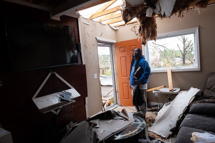 230327-West Point-Adrian McFarlin looks at the roof in the room that was his wife’s office Monday, Mar. 27, 2023, after a tornado ripped through his West Point neighborhood, destroying several houses. Neither McFarlin nor his wife were injured.  Ben Gray for the Atlanta Journal-Constitution
