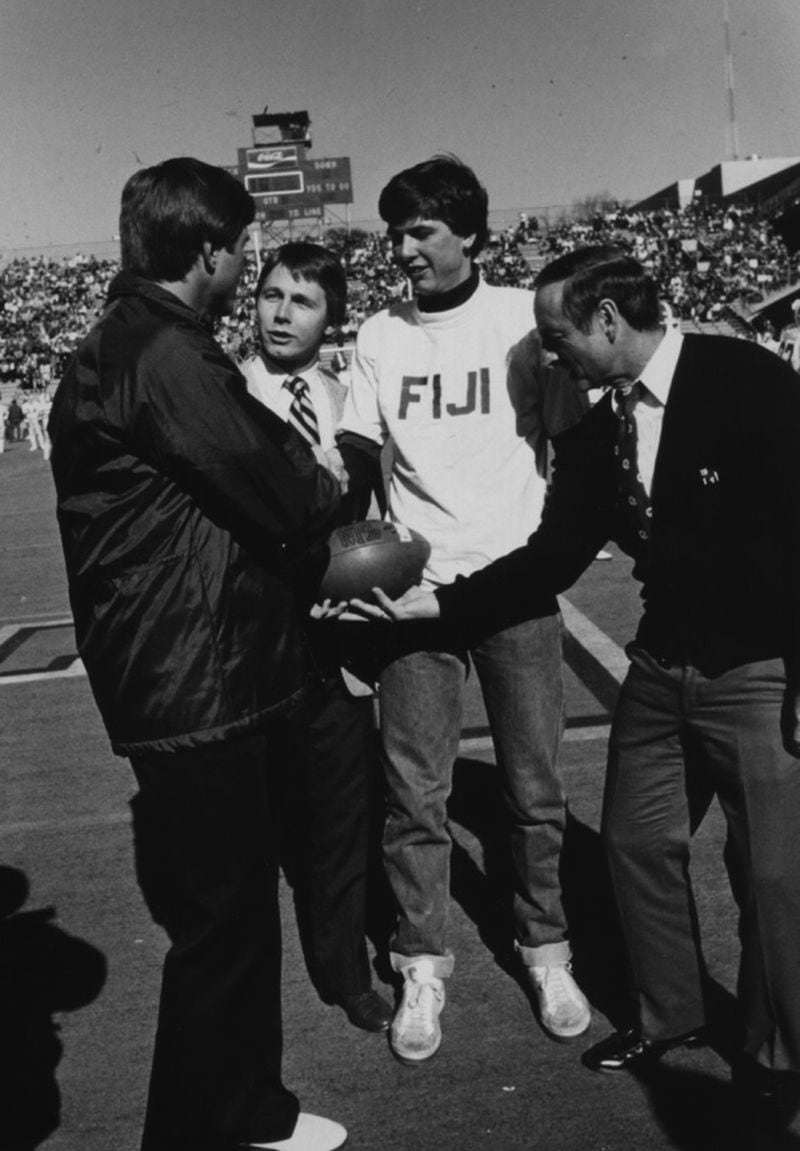 At the 1981 Georgia-Georgia Tech game, Yellow Jackets coach Bill Curry (left) and Bulldogs coach Vince Dooley (right) greet fraternity brothers Mark Johnson and Mike Spears as part of a leukemia fund drive at Grant Field. (Georgia Tech Archives)