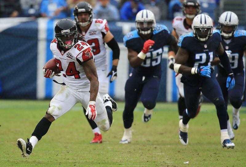 102515 NASHVILLE: -- Falcons running back Devonta Freeman breaks away from Titans defenders during the second half in a football game on Sunday, Oct. 25, 2015, in Nashville. Curtis Compton / ccompton@ajc.com