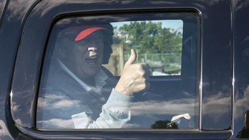 President Donald Trump acknowledges supporters as he returns from a golf outing on Sunday.