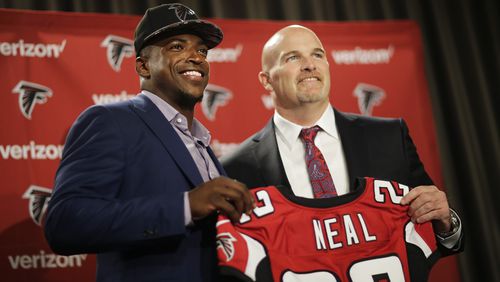 Atlanta Falcons first round draft pick Keanu Neal, left, poses for a photo with his jersey and head coach Dan Quinn following a news conference at the football team's practice facility Friday, April 29, 2016, in Flowery Branch, Ga. (AP Photo/David Goldman)