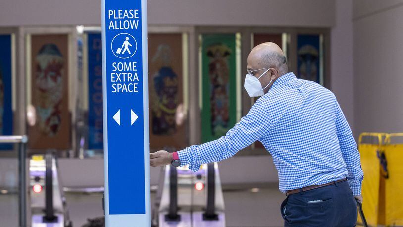 A man uses a hand sanitizing station located in the domestic terminal at Hartsfield-Jackson International Airport in Atlanta, Wednesday, May 20, 2020. (ALYSSA POINTER / ALYSSA.POINTER@AJC.COM)