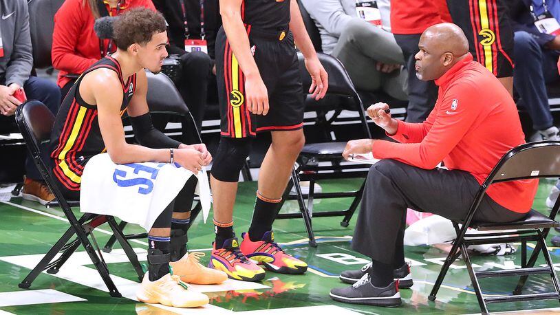 Hawks interim head coach Nate McMillan confers with Trae Young during a time out after falling behind 57-41 against the Milwaukee Bucks in the second quarter of Game 2 of the Eastern Conference finals Friday, June 25, 2021, in Milwaukee. (Curtis Compton / Curtis.Compton@ajc.com)