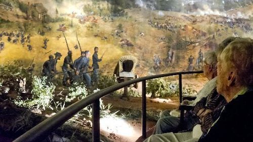 Visitors in this 2013 photograph look at different scenes from the Battle of Atlanta depicted in the Cyclorama painting in Grant Park. The attraction is closing at the end of June in preparation for its relocation and restoration at the Atlanta History Center.. JONATHAN PHILLIPS / SPECIAL