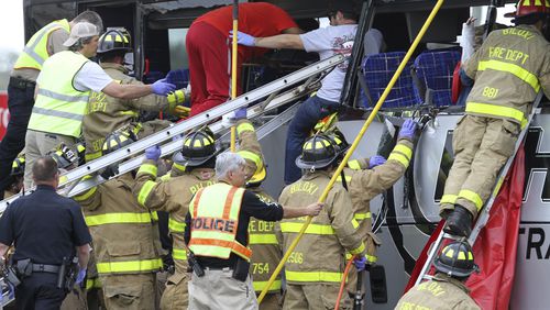 Rescue personnel work to remove passengers from a charter bus that was hit by a CSX train at the Main Street crossing in Biloxi, Miss., on Tuesday, March 7, 2017. The bus was carrying 50 people from Austin, Texas, Biloxi Police Chief John Miller said at a news conference. He said authorities believe the bus was stopped on the tracks at the time of the crash, but they don't yet know why. ( John Fitzhugh/The Sun Herald via AP)
