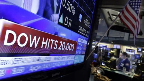 A television screen displays the news Wednesday as the Dow broke 20,000. The index of 30 leading stocks has tripled in the past eight years. (AP Photo/Richard Drew)