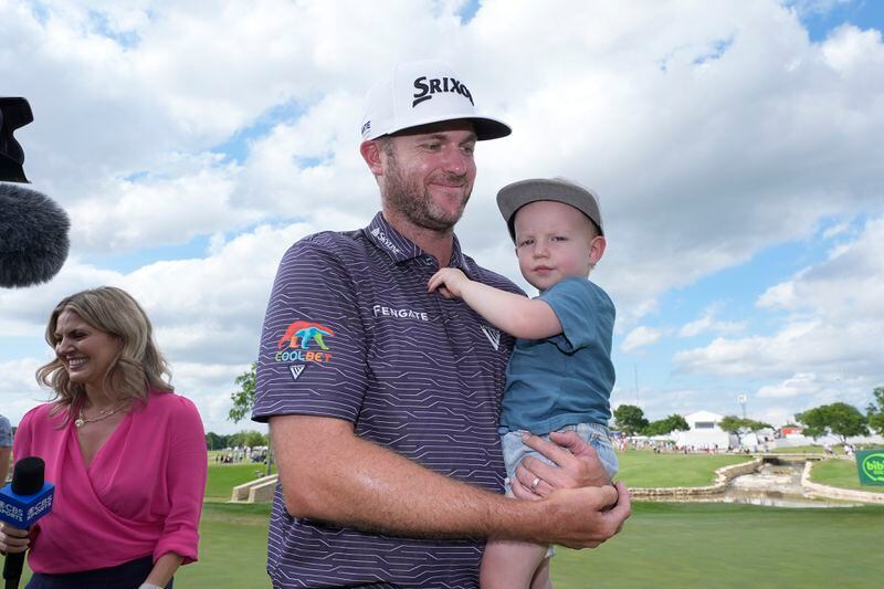 Taylor Pendrith, center, holds his son Hayes after winning the Byron Nelson golf tournament in McKinney, Texas, Sunday, May 5, 2024. (AP Photo/LM Otero)