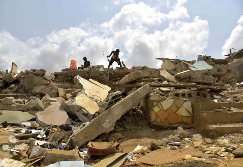 People search through a demolished house in the Gesco neighborhood of Abidjan, Ivory Coast, Wednesday, Feb. 28, 2024. Rapid urbanisation has led to a population boom and housing shortages in Abidjan, where nearly one in five Ivorians reside, many of them in low-income, crowded communes like the ones in the Gesco and Sebroko districts being demolished on public health grounds. (AP Photo/Diomande Ble Blonde)