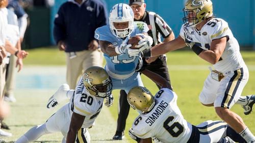 North Carolina’s Bug Howard (13) attempts to stretch for a first down as Georgia Tech’s Lawrence Austin (20), Lamont Simmons (6), and Brant Mitchell (51) defend during the first half of an NCAA college football game Chapel Hill, N.C., Saturday, Nov. 5, 2016. (AP Photo/Ben McKeown)