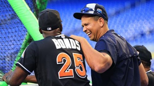 Former New York Yankees designated hitter Alex Rodriguez, right, talks with Miami Marlins hitting coach Barry Bonds before an exhibition baseball game in April. (AP photo)