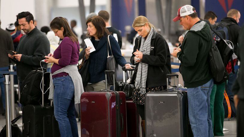 Delta passengers wait in line at Hartsfield-Jackson International earlier this month. BRANDEN CAMP/SPECIAL