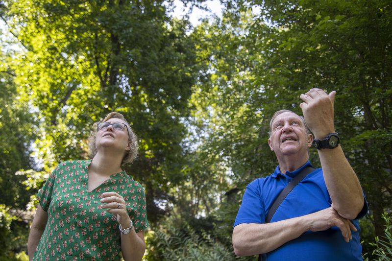 Steve Rushing and his neighbor Erin Braden watch a Red-tailed Hawk as it flies high above the trees in his driveway at his residence in Decatur, Tuesday, June 15, 2021. (Alyssa Pointer / Alyssa.Pointer@ajc.com)