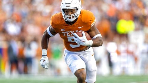 Texas running back Bijan Robinson carries against West Virginia during the first half of an NCAA college football game Saturday, Oct. 1, 2022, in Austin, Texas. (AP Photo/Stephen Spillman)
