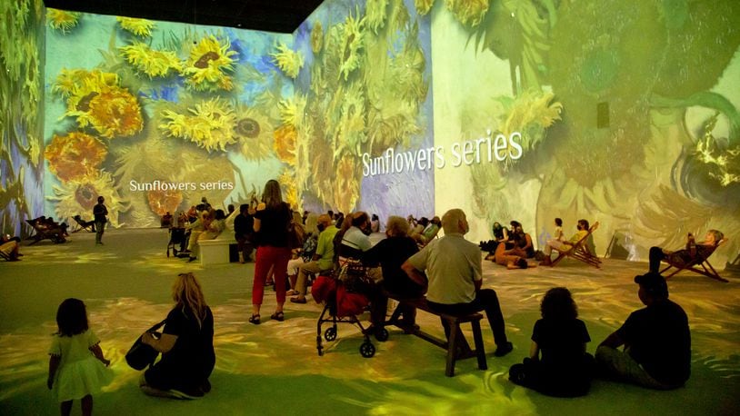 People sit and watch the two-story projections during the Van Gogh: The Immersive Experience at the Pullman Yard in Atlanta Thursday, May 20, 2021.  STEVE SCHAEFER FOR THE ATLANTA JOURNAL-CONSTITUTION
