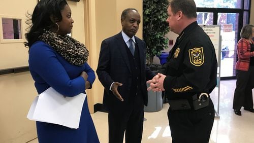 DeKalb County CEO Michael Thurmond (center) speaks to Police Chief James Conroy (right) before casting the deciding vote on new booting regulations during a meeting on Dec. 4, 2018. La’Keitha Carlos, Thurmond’s chief of staff, looks on. TIA MITCHELL/TIA.MITCHELL@AJC.COM