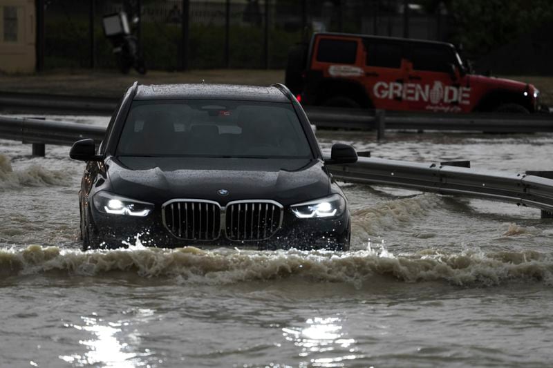 An SUV stalls out while trying to pass through standing water in Dubai, United Arab Emirates, Tuesday, April 16, 2024. Heavy rains lashed the United Arab Emirates on Tuesday, flooding out portions of major highways and leaving vehicles abandoned on roadways across Dubai. Meanwhile, the death toll in separate heavy flooding in neighboring Oman rose to 18 with others still missing as the sultanate prepared for the storm. (AP Photo/Jon Gambrell)
