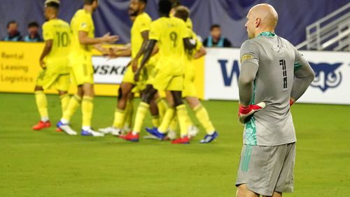 Atlanta United goalkeeper Brad Guzan (1) waits for play to resume as Nashville SC players celebrate after a goal during the first half of an MLS soccer match Saturday, Sept. 12, 2020, in Nashville, Tenn. (AP Photo/Mark Humphrey)