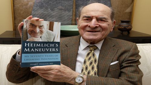 In this Wednesday, Feb. 5, 2014 photo, Dr. Henry Heimlich holds his memoirs prior to being interviewed at his home in Cincinnati. Heimlich is known for developing the Heimlich maneuver that has been used to clear obstructions from the windpipes of choking victims around the world for four decades. (AP Photo/Al Behrman)