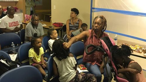 Garnell Hodge, a resident of Kingsley Village, and her daughters, Lonnie, 8, and Fantasia, 4, attended a tenants meeting with police, county officials and management to address housing conditions. Hodge said she is still waiting for management to take care of the mold in her apartment. (Meris Lutz/AJC)
