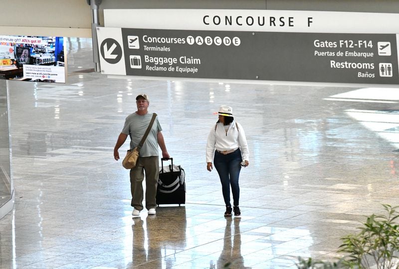 International travelers walk with their luggage in Concourse F at Maynard H. Jackson Jr. International Terminal on Friday, April 29, 2022. (Hyosub Shin / Hyosub.Shin@ajc.com)