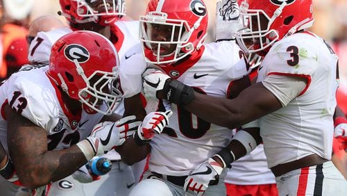Georgia defensive back J.R. Reed (center) celebrates his interception of Tennessee quarterback Quinten Dormady with teammates during the second quarter in a NCAA college football game on Saturday, September 30, 2017, in Knoxville.   Curtis Compton/ccompton@ajc.com
