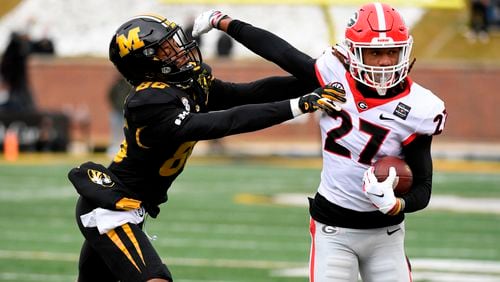 Georgia defensive back Eric Stokes (27) runs with the ball after intercepting a pass intended for Missouri wide receiver Tauskie Dove (86) during the first half Saturday, Dec. 12, 2020, in Columbia, Mo. (L.G. Patterson/AP)
