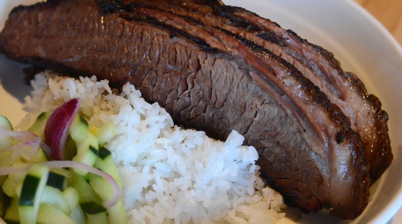 Platters at Smoke and Duck Sauce let you have a combination of flavors, such as smoked brisket with Japanese steamed rice and pickled cucumbers. STYLED BY CHEF JOE CHIN LOY; CONTRIBUTED BY ADRIENNE HARRIS