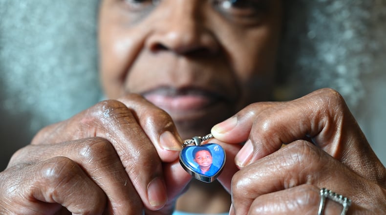 Glenda Mack holds a necklace that includes a photo of her grandson David. The 12-year-old was found shot to death in February, not far from their southwest Atlanta home.