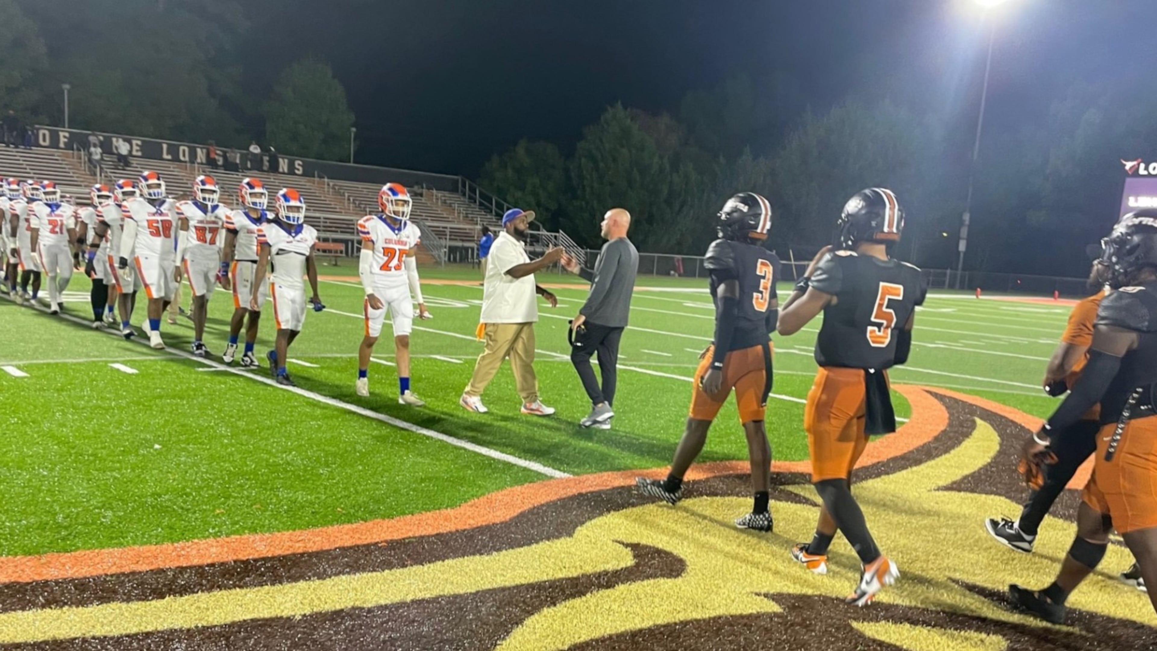 Head coaches Greg Barnett of Columbia and Bobby May of Kell meet at midfield as players go through the handshake line after Kell's 48-0 victory on Friday, Sept. 19, 2025, at Kell High School. (Chip Saye/AJC)