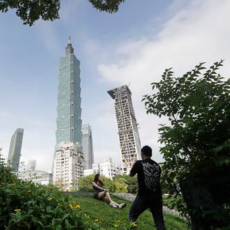FILE - People take photos with the iconic Taipei 101 skyscraper in the background in Taipei, Taiwan, April 27, 2025. (AP Photo/Chiang Ying-ying, File)