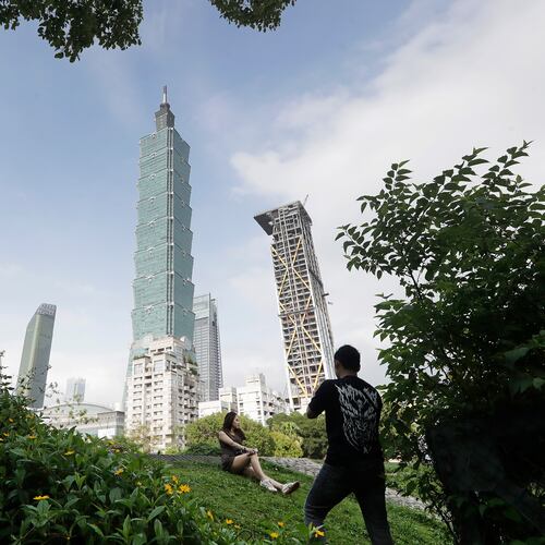 FILE - People take photos with the iconic Taipei 101 skyscraper in the background in Taipei, Taiwan, April 27, 2025. (AP Photo/Chiang Ying-ying, File)