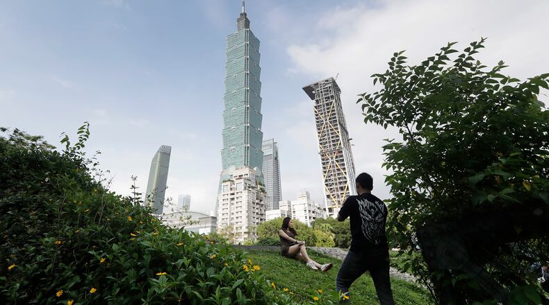 FILE - People take photos with the iconic Taipei 101 skyscraper in the background in Taipei, Taiwan, April 27, 2025. (AP Photo/Chiang Ying-ying, File)