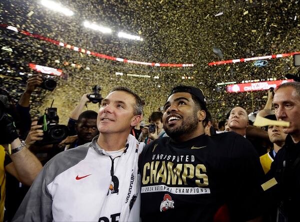 CORRECTS PLAYER AT RIGHT TO EZEKIEL ELLIOTT- Ohio State head coach Urban Meyer and Ezekiel Elliott celebrate after the NCAA college football playoff championship game against Oregon Monday, Jan. 12, 2015, in Arlington, Texas. Ohio State won 42-20. (AP Photo/David J. Phillip) Urban Meyer and Ezekiel Elliott admire their handiwork. (David J. Phillip/AP photo)