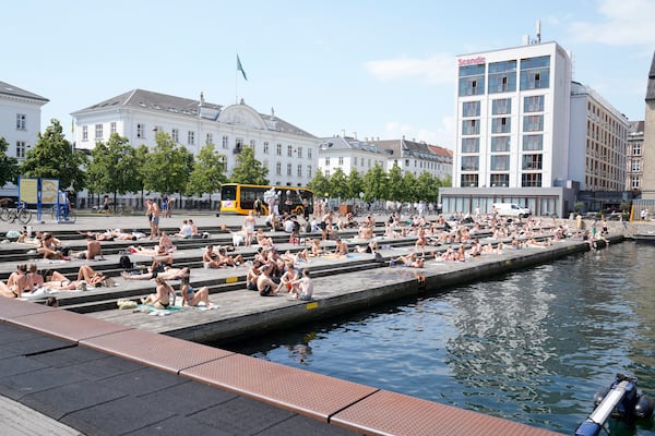 People relax at the the harbour bath at Ofelia Square in Copenhagen, Denmark, Wednesday July 2, 2025. (Thomas Traasdahl/Ritzau Scanpix via AP)