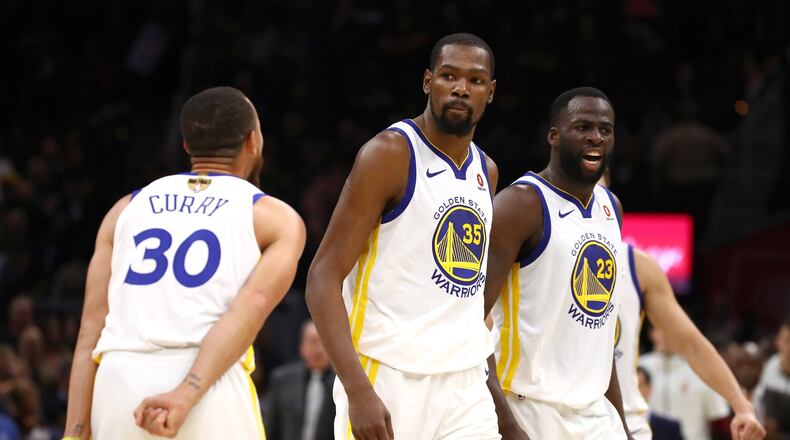 Steph Curry and Draymond Green (right) of the Golden State Warriors celebrate with Kevin Durant during Wednesday night’s win over the Cleveland Cavaliers. GREGORY SHAMUS/GETTY IMAGES