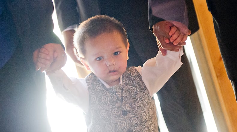 July 2, 2014 Atlanta - Bounkham Phonesavanh (center) holds onto his mother Alecia's and father Bounkham Sr.'s hands as they walk to their table during a farewell breakfast at Delightful Eatz in Atlanta on Wednesday, July 2, 2014. Known as Baby Bou Bou, the young child has been in the hosital for the past five weeks after a botched drug raid in Habersham County. The family is moving back to Wisconsin later this week. JONATHAN PHILLIPS / SPECIAL