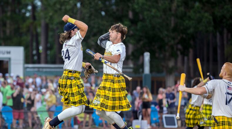 Wearing a uniform of yellow plaid kilts, Savannah Bananas pitcher Jared Donaldson, right, and outfielder Beau Brewer leap in the air during team introductions before a game with the Holly Springs Salamanders. (AJC Photo/Stephen B. Morton)
