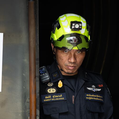A rescuer looks on at the entrance door of the music bar where a fire killed a number of people in Bangkok, Thailand, Tuesday, July 14, 2026. (AP Photo/Wason Wanichakorn)