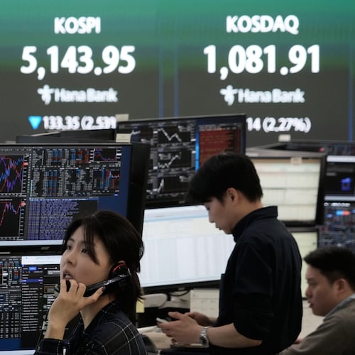 A currency trader talks on the phone near a screen showing the Korea Composite Stock Price Index (KOSPI), top center, and the foreign exchange rate between U.S. dollar and South Korean won, top center left, at the foreign exchange dealing room of the Hana Bank headquarters in Seoul, South Korea, Tuesday, March 31, 2026. (AP Photo/Ahn Young-joon)