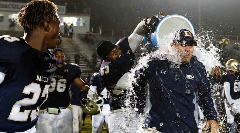 10-26-18 - Dacula, GA - Dacula's Adam Watkins (63) dumps a cooler of ice water on Dacula head coach Clint Jenkins after last year’s game against Lanier that decided the Region 8-AAAAAA championship. (Casey Sykes for The Atlanta Journal-Constitution)