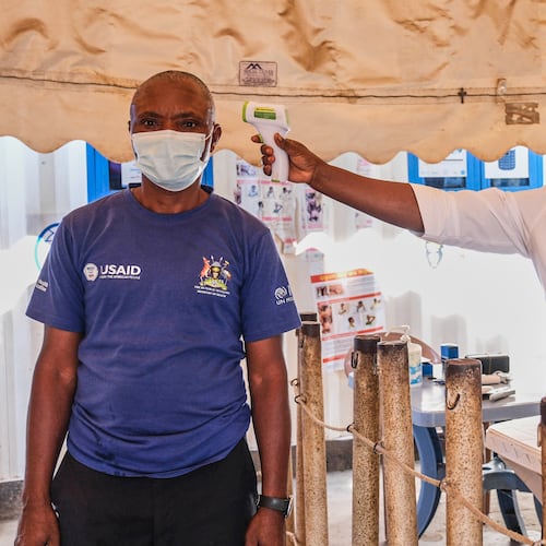 FILE - A health worker checks an individual's temperature at a temporary health clinic at the Mpondwe border crossing linking Uganda and the Democratic Republic of the Congo, Thursday, June 4, 2026. (AP Photo/Hajarah Nalwadda, File)
