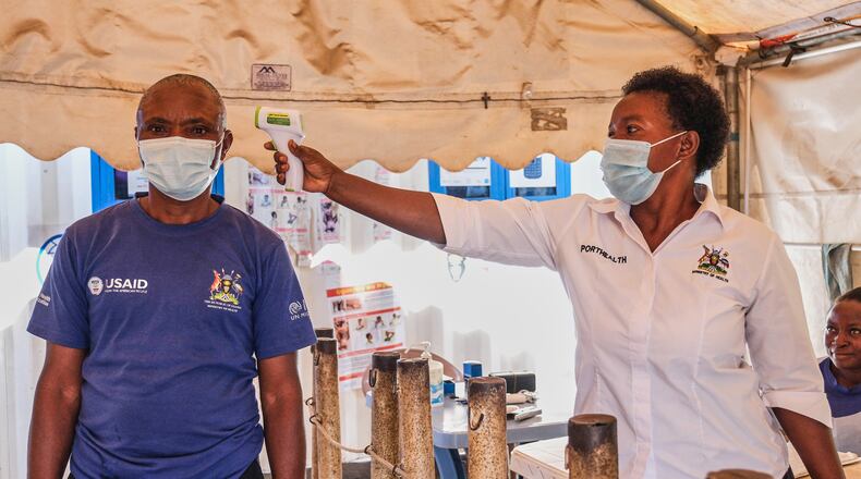 FILE - A health worker checks an individual's temperature at a temporary health clinic at the Mpondwe border crossing linking Uganda and the Democratic Republic of the Congo, Thursday, June 4, 2026. (AP Photo/Hajarah Nalwadda, File)