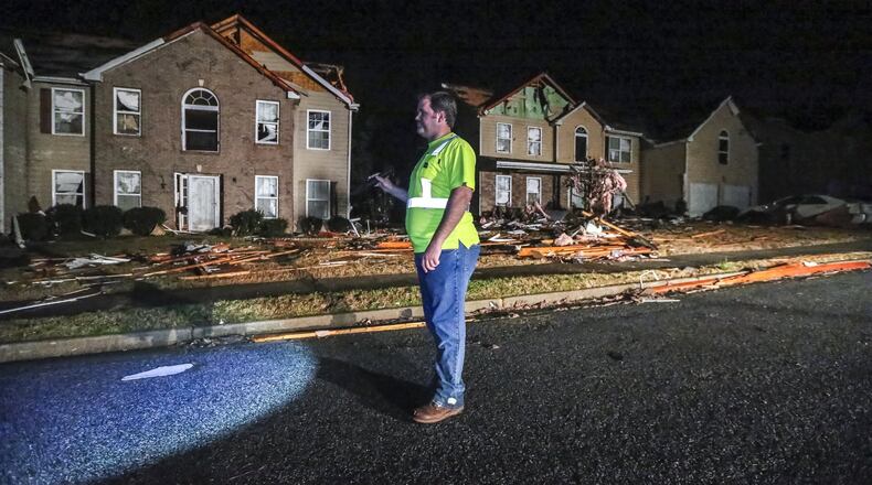 Cal Welk with Champion Construction surveys damage on Jumpers Trail on Tuesday after a powerful storm system swept through North Georgia Monday, sending trees into roads, damaging homes and businesses, knocking out power to thousands. JOHN SPINK/JSPINK@AJC.COM