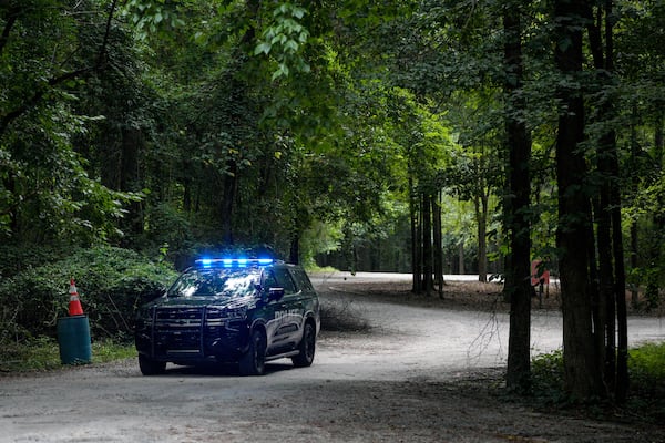 A police cruiser sits near the parking lot at Constitution Lakes Park close to the start of the Doll's Head Trail. (Ben Hendren for The Atlanta Journal-Constitution)