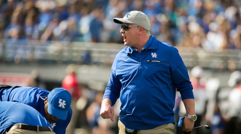 Kentucky head coach Mark Stoops, center, argues with referee Reggie Smith, left, during the first half of the TaxSlayer Bowl NCAA college football game against Georgia Tech, Saturday, Dec. 31, 2016, in Jacksonville, Fla. (AP Photo/Stephen B. Morton)