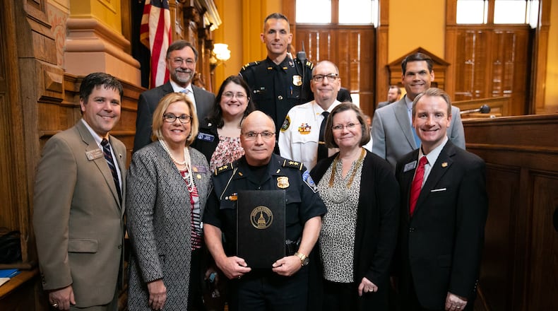 Suwanee Police Chief Mike Jones was recently honored at the State Capitol as Georgia’s 2018-2019 Chief of the Year. Top row: Suwanee Police Captain Cass Mooney; Second row, left to right: Suwanee Mayor Jimmy Burnette, Senator Zahra Karinshak, President of the Georgia Association of Chiefs of Police and City of Jefferson Chief Joe Wirthman , Georgia Lieutenant Governor Geoff Duncan; Bottom row, left to right: Senator PK Martin, Senator Renee Unterman, Chief Mike Jones, Mrs. Debbie Anne Jones, Senator John Albers. (Courtesy City of Suwanee)