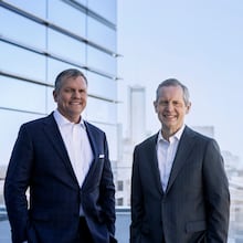 Jim Squires (right) will retire as CEO of Norfolk Southern in May 2022. Alan Shaw (left), chief marketing officer, will succeed him. Squires and Shaw are standing on a balcony at Norfolk Southern's Midtown headquarters.