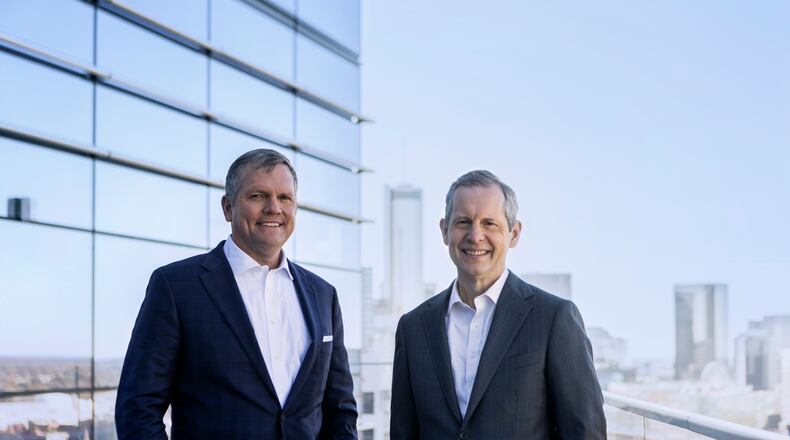 Jim Squires (right) will retire as CEO of Norfolk Southern in May 2022. Alan Shaw (left), chief marketing officer, will succeed him. Squires and Shaw are standing on a balcony at Norfolk Southern's Midtown headquarters.